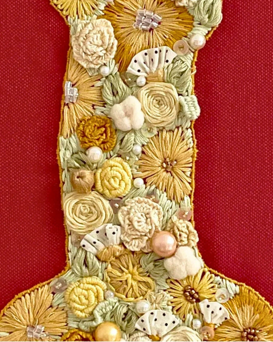 overflowing with soft textures—packed tight with hand-embroidered floral rosettes, delicate woven daisies, soft pearl accents, and golden thread-work.